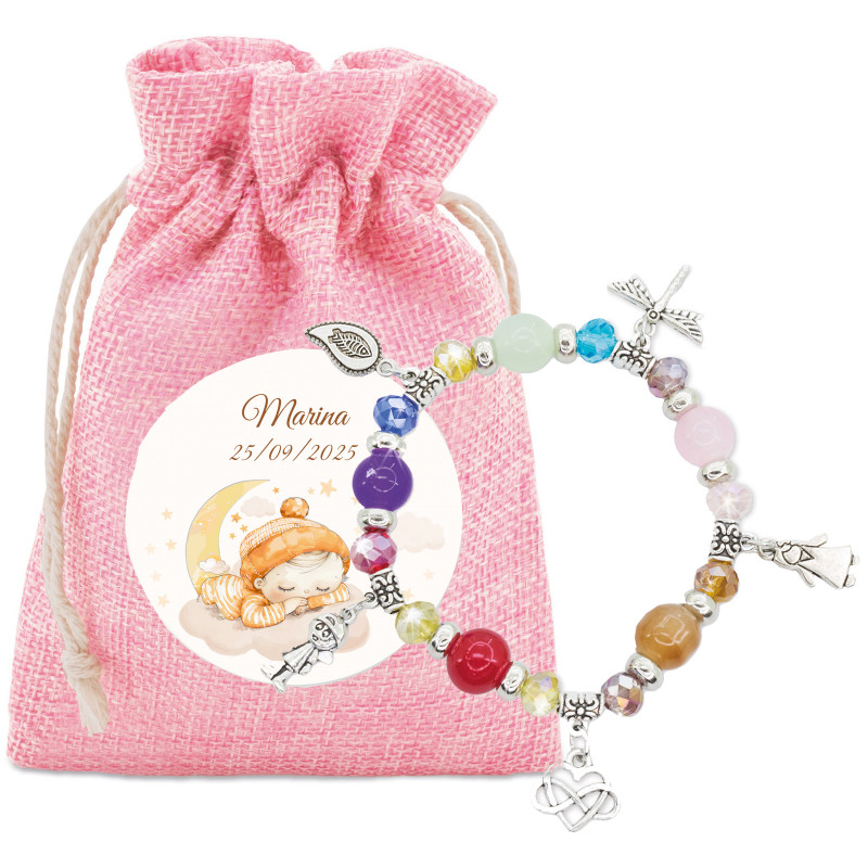 Bracelet avec perles et breloques colorées dans une pochette en tissu rose et adhésif spécial baptême