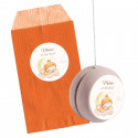 Yo-yo en bois personnalisé avec autocollant bébé dans une enveloppe orange personnalisée assortie