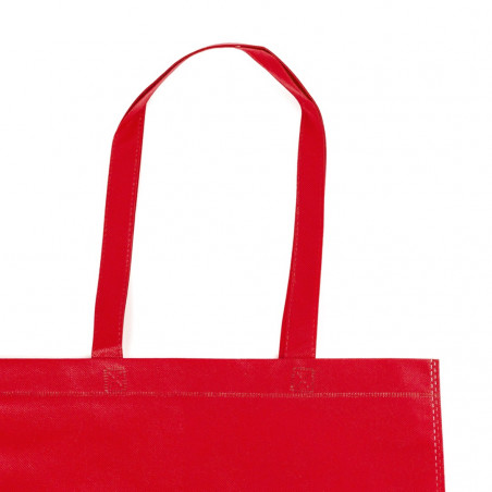 Culotte polaire rouge dans un sac assorti à longue poignée avec étiquette personnalisée et autocollant de Noël